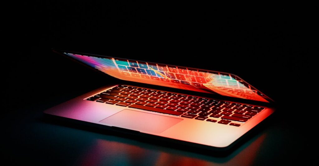 Laptop partially opened, emitting vibrant multicolored lights in dark setting.